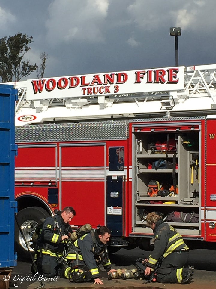 Firefighters from the Woodland Fire Department change out their depleted oxygen tanks for fresh, full tanks before returning into the building.