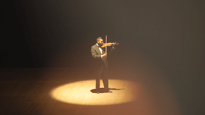 Amit (Albert Thakur) performs a violin solo during his recital in a scene from Crescendo 