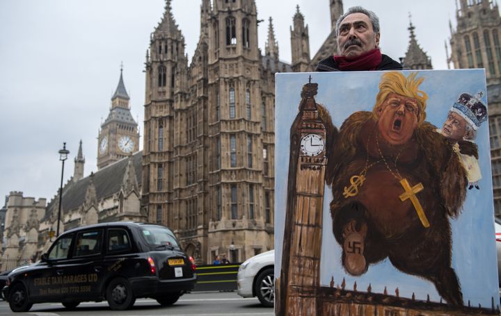 Artist Kaya Mar holds his latest political satire painting of Donald Trump depicted as King Kong with Queen Elizabeth II climbing Big Ben on Feb. 8 in London, England, after news that Trump would be invited to the U.K. on a state visit sometime this year.