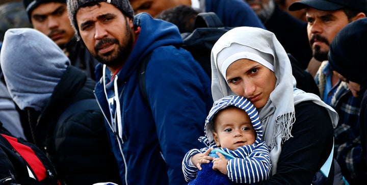 A migrant woman carries a baby as she walks towards the Austrian border from Hegyeshalom, Hungary September 29, 2015.