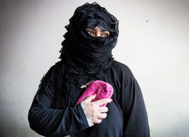 Shiraz Shoibi, 38, holds her most treasured possession: a small, hot-pink purse that her husband gave her just before he was killed. 