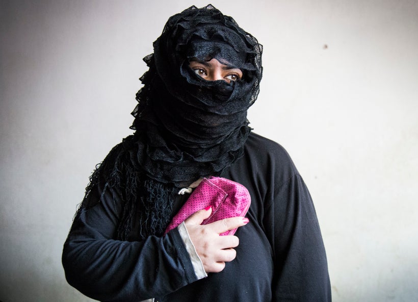 Shiraz Shoibi, 38, holds her most treasured possession: a small, hot-pink purse that her husband gave her just before he was