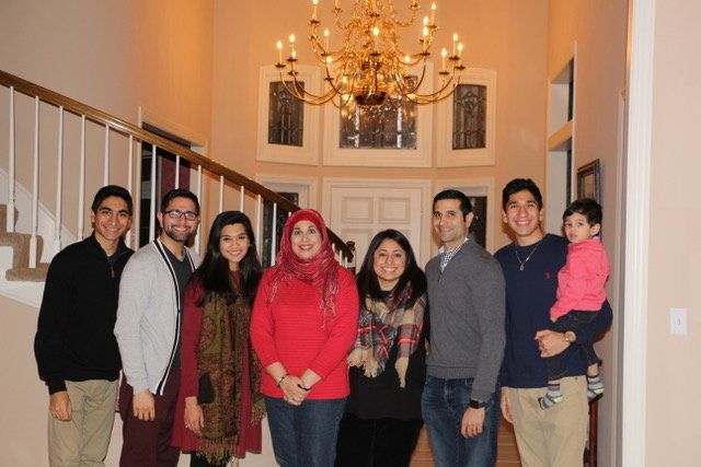 Mahnaz Shabbir with her four sons, two daughters-in-law and grandchild in her Kansas City home.
