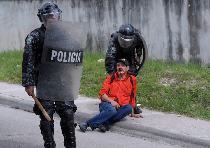 Riot policemen detain an injured peasant farmer as they evicted protesters near the Supreme Court in Tegucigalpa August 21, 2012. Riot policemen fired tear gas to remove peasant farmers who set up barricades and burned tires to block a main avenue as they demanded that a decree disallowing Bajo Aguan farmers in northern Honduras from being armed, be ruled unconstitutional by the Supreme Court.