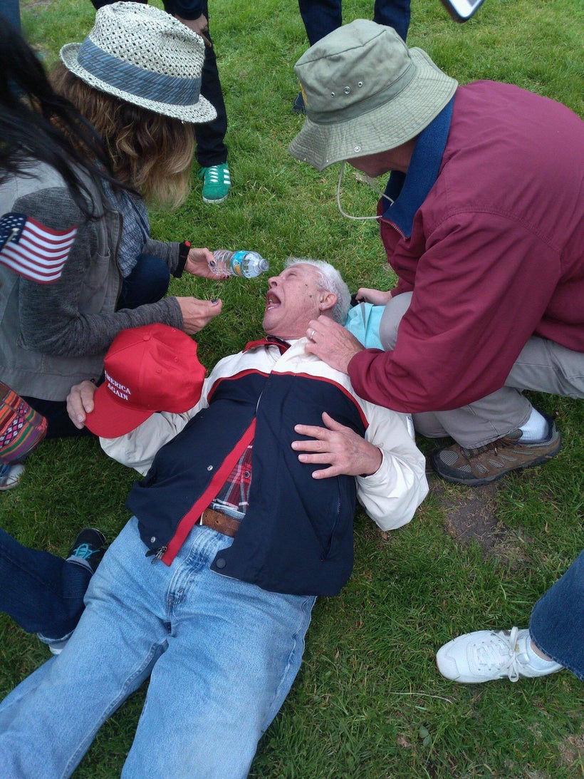Man being treated by fellow rally attendees after being pepper-sprayed