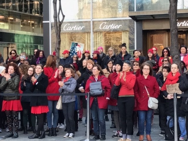 Women wear red at a #DayWithoutAWoman rally in Central Park, NYC.