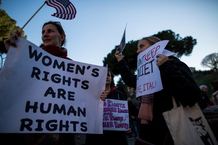 Women carrying American flags and signs are seen marching for equal rights in Rome, Italy as part of the International Women's Day on Wednesday.