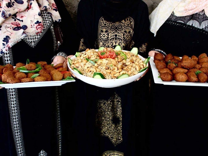 Rawa'a, Dalal, and Manahel, the trio of chefs at Karam Kitchen, with a sample of their food.