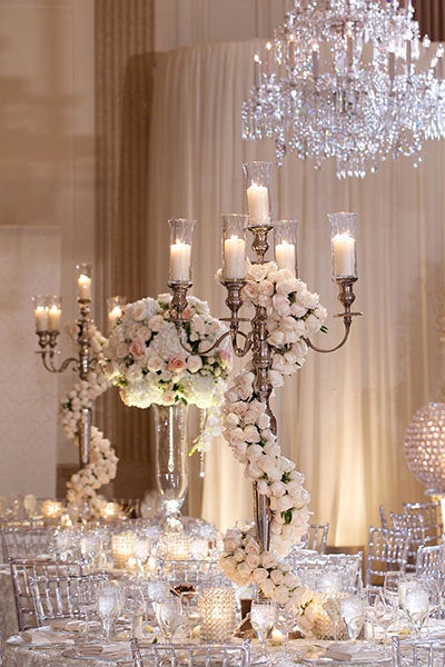 Wrap your candelabras in roses for an even more romantic look. <em>Related: <a href="http://www.bridalguide.com/planning/the-details/decor-flowers/lighting-ideas#154806" target="_blank" role="link" rel="nofollow" class=" js-entry-link cet-external-link" data-vars-item-name="25 Ways to Transform Your Wedding With Lighting" data-vars-item-type="text" data-vars-unit-name="58c0aaaee4b0a797c1d398f0" data-vars-unit-type="buzz_body" data-vars-target-content-id="http://www.bridalguide.com/planning/the-details/decor-flowers/lighting-ideas#154806" data-vars-target-content-type="url" data-vars-type="web_external_link" data-vars-subunit-name="article_body" data-vars-subunit-type="component" data-vars-position-in-subunit="13">25 Ways to Transform Your Wedding With Lighting</a></em>