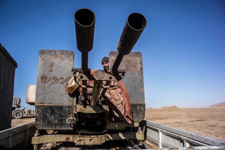 A member of the People's Protection Units (YPG) stands watch at the frontline of Raqqa fights against ISIS a year ago.