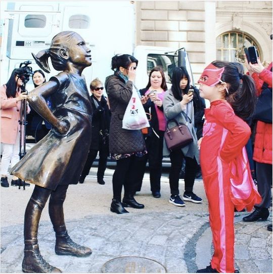 Five-year-old Abrianna Tomar Almonte posed with "The Fearless Girl" on Wall Street wearing a Owlette costume from the show "PJ Masks."