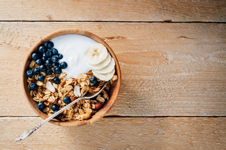 Homemade oatmeal granola with peanuts, blueberry and banana in wooden bowl, sunny morning tataks via Getty Images