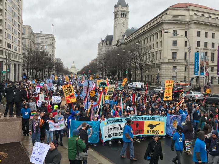 Protesters marched Friday, carrying a sign reading "Recognize Indigenous People's Rights. We Exist. We Resist. We Rise."