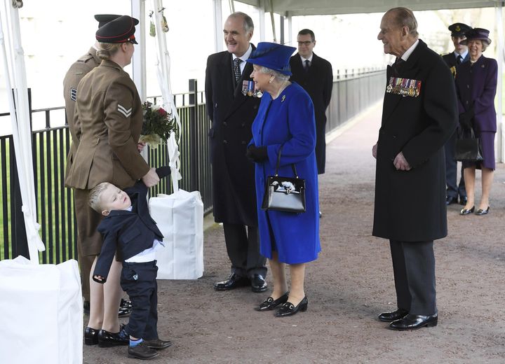 Two-year-old Alfie Lun is held by his mother as Britain's Queen Elizabeth II arrives to unveil The Iraq and Afghanistan memorial at Victoria Embankment Gardens in central London on March 9, 2017.