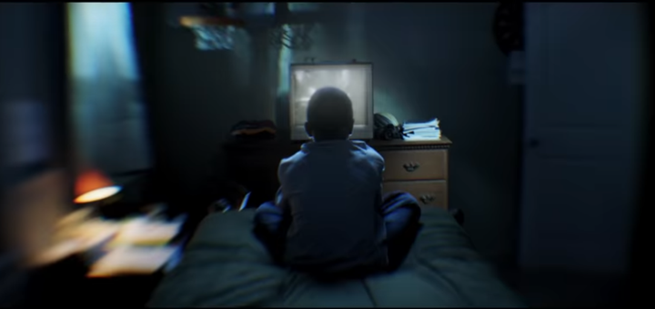 A young Chris (Zailand Adams) watches TV while at home.