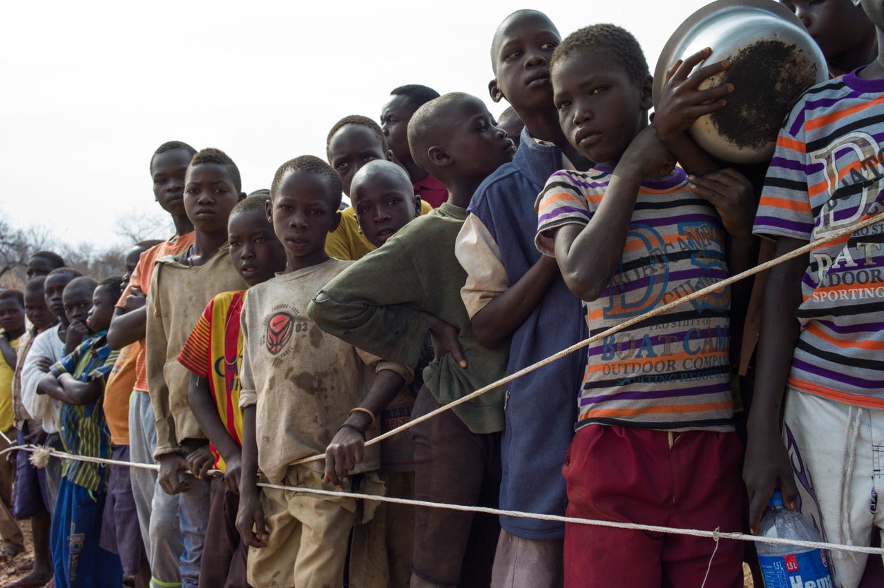 South Sudanese children wait for a food delivery at a refugee camp in Uganda. Hundreds of thousands of people have crossed into Uganda to escape violence and abuse.