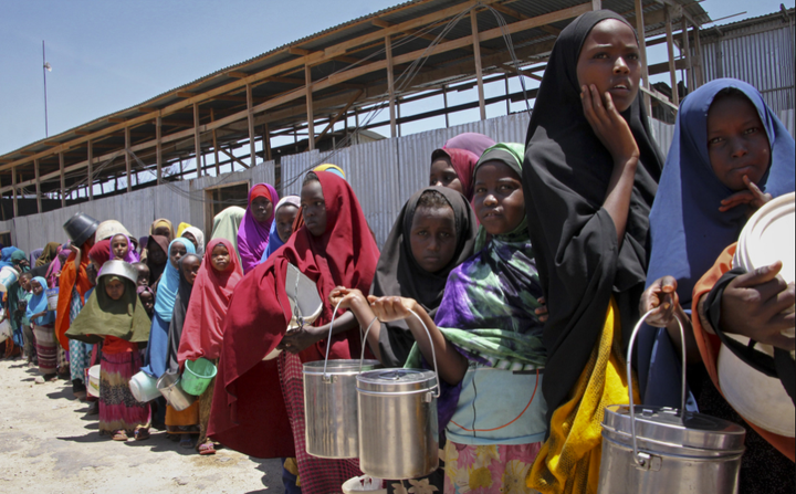 Somali girls standing in a queue to receive food handouts at a feeding center in Mogadishu, Somalia. 