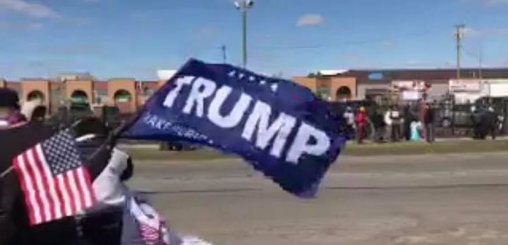 A Trump flag is waved in front of a rally against Islamophobia in Dearborn, Mich.