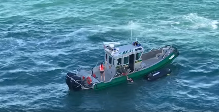 Two jet skiers are pulled to safety just feet from a massive cruise ship.