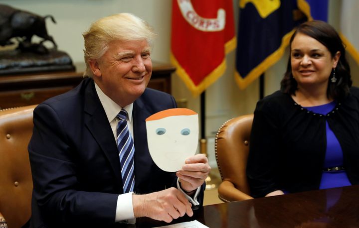 President Donald Trump holds up a card made by a child and given to him by an attendee of a health care meeting at the White House on March 13. 