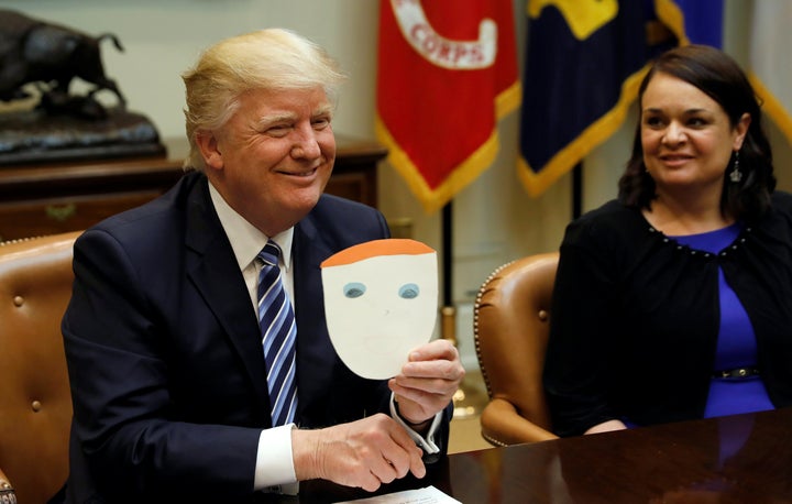 President Donald Trump holds up a card made by a child and given to him by an attendee of a health care meeting at the White House on March 13. 