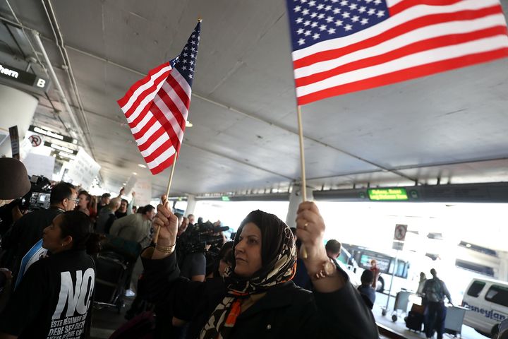 A protester waves American flags during a demonstration against the immigration ban that was imposed by U.S. President Donald Trump at Los Angeles International Airport on January 29, 2017.