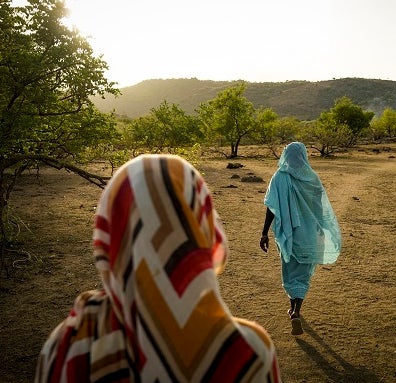 <p>Two women waking in the Nuba Moutnains</p>