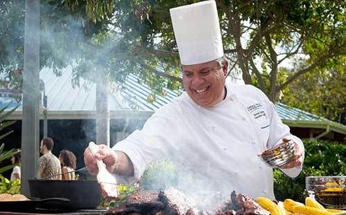 <p>Executive Chef Héctor Colón fusses over some of the items offered at SeaWorld Orlando’s Seven Seas Food Festival.</p>