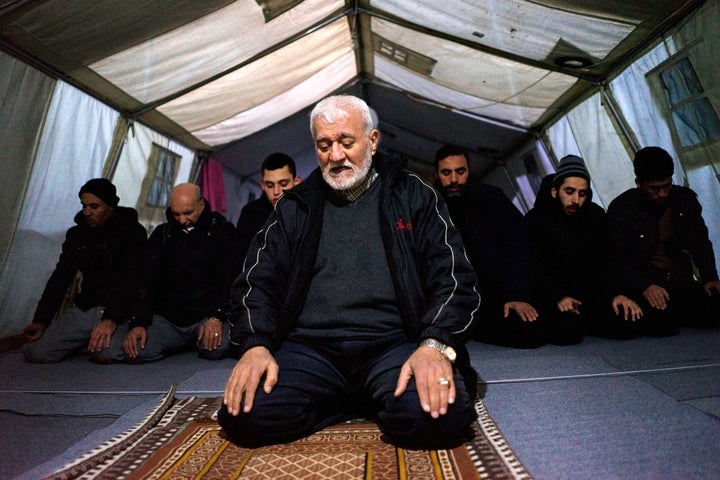 Imam Ali, a 68-year-old Palestinian refugee from Syria, leads prayers in the tented mosque at the Softex refugee camp outside Thessaloniki.