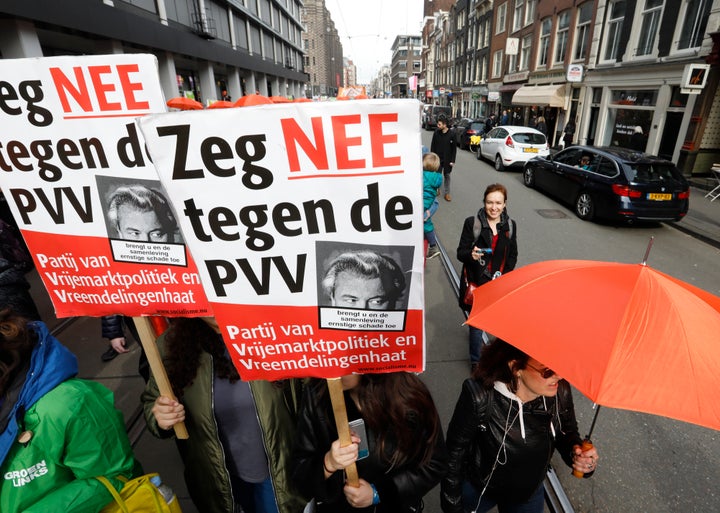 Demonstrators carrying orange umbrellas and signs reading "Say no to PVV", march in Amsterdam on March 11.