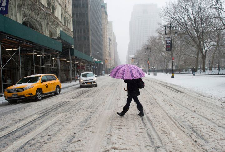 A woman makes her way across snowy streets in New York during Storm Stella 