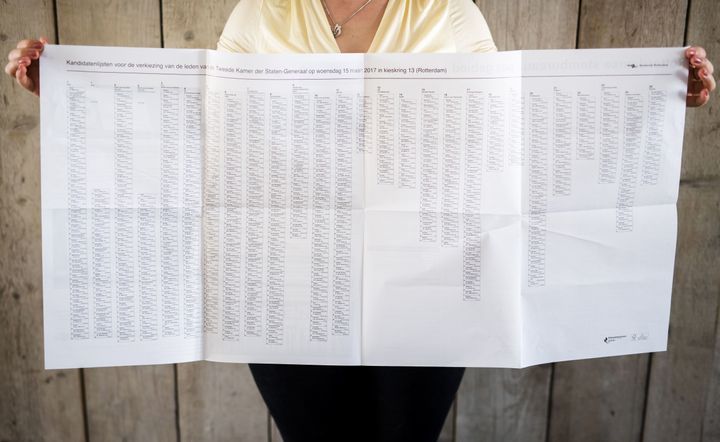 A woman holds up an enormous election ballot for the Dutch general election on March 15, 2017.