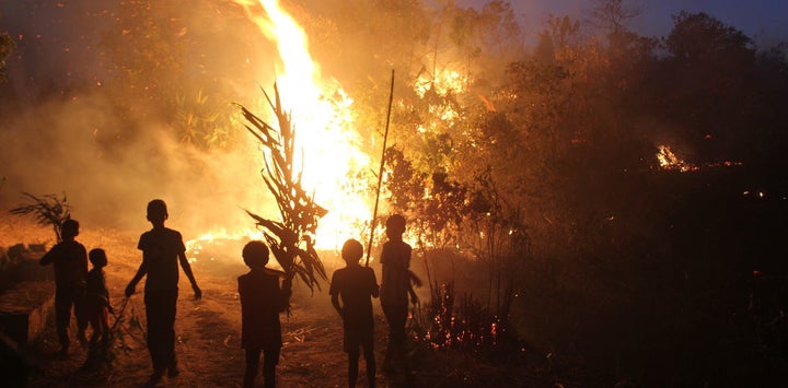 A bunch of Khasi children fire-fighters watch on, as the flames erupt in a slash and burn episode.