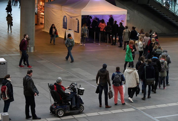 People queue to cast their vote for the general elections in The Hague. 