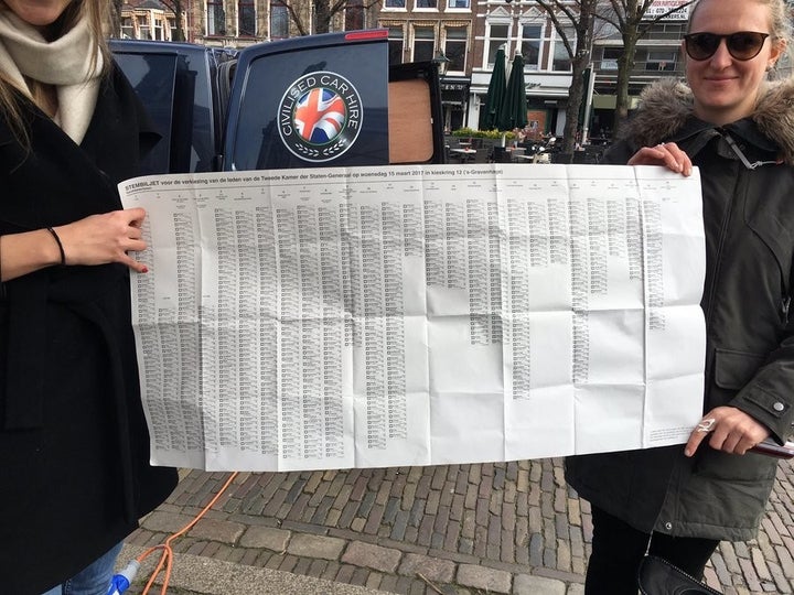 Dutch voters hold up an election ballot