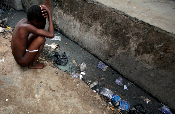 A child squats by an open sewer in central Lagos. A 2016 WaterAid report finds almost 70 percent of Nigeria's urban population does not have access to safe, private toilets and 1 in 4 people practice open defecation.