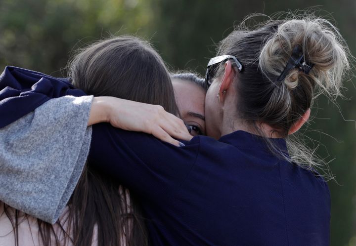 People embrace near the school after the shooting