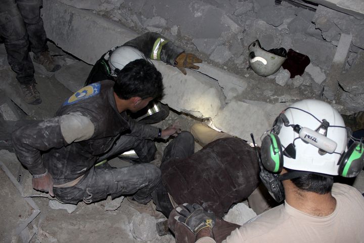 Civil defense team members and others try to rescue people trapped under debris after an aerial attack in the Etarib district of Aleppo, Syria, on March 16.