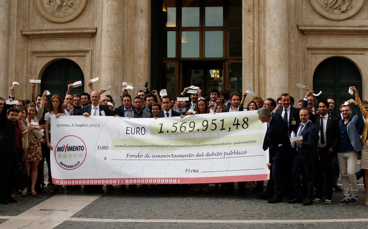 Five Star Movement deputies hold a banner during a demonstration called "Restitution Day," in front of the Italian Parliament