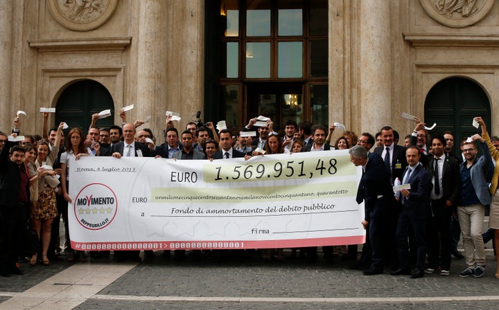 Five Star Movement deputies hold a banner during a demonstration called "Restitution Day," in front of the Italian Parliament. Rome, July 4, 2013. 