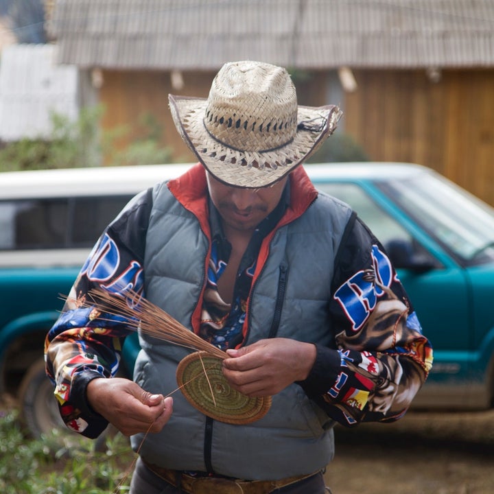 A local Mexican man begins work on a pine needle basket at the entrance of one of the monarch reserves, weaving each needle into a piece of art. © Court Whelan