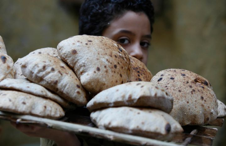 A child balancing a bread tray on his shoulder in Cairo.