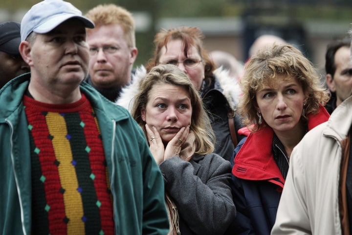 People watch a TV broadcast near to the crime scene where Dutch filmmaker Theo van Gogh was killed in Amsterdam. Nov. 2, 2004.