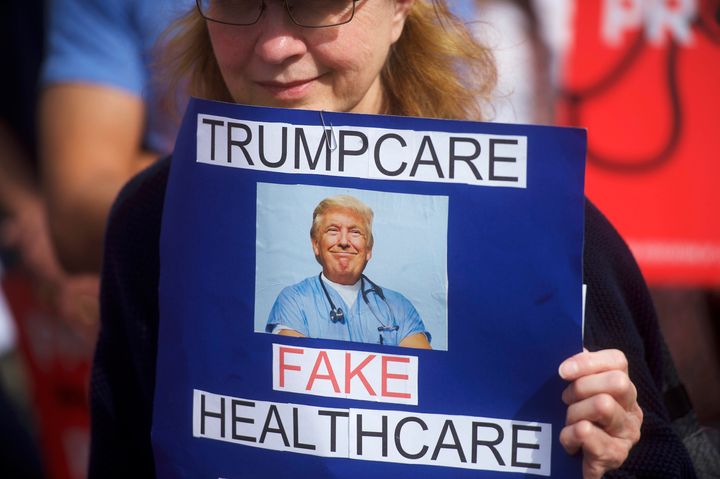 A demonstrator holds a sign reading 'Trumpcare - Fake Healthcare' during a health care rally at Thomas Paine Plaza on February 25.