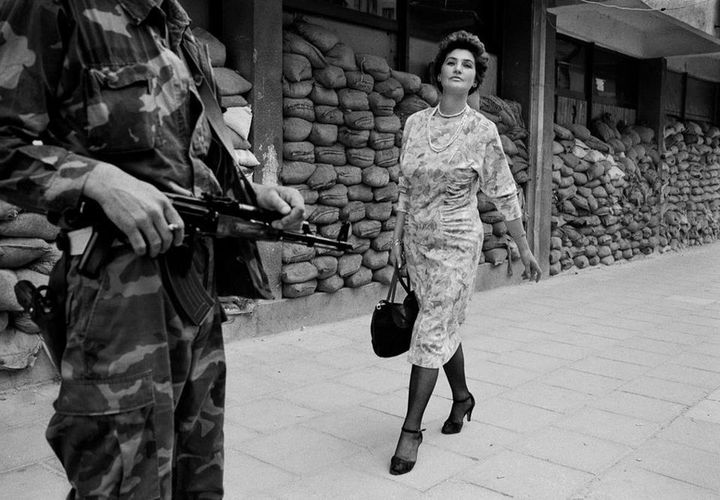 SARAJEVO, BOSNIA - 1995: In the dangerous suburb of Dobrinja, Meliha Varesanovic walks proudly and defiantly to work during the Siege of Sarajevo, 1995. Her message to the watching Serb gunmen who surround her city is simple, "you will never defeat us." T