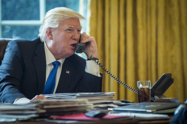 President Donald Trump speaks on the phone with Vladimir Putin during the first official phone talks in the Oval Office of the White House, on Saturday, Jan. 28, 2017.