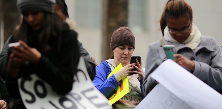 Protesters post a hashtag to social media together to make it trend as they denounce policies of President Donald Trump at th