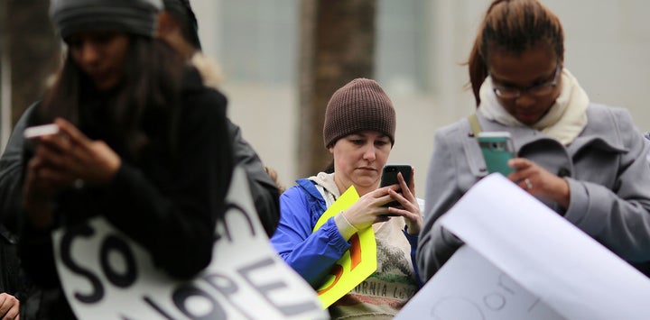 Protesters post a hashtag to social media together to make it trend as they denounce policies of President Donald Trump at the Not My President’s Day Rally in Los Angeles, California February 20, 2017. 