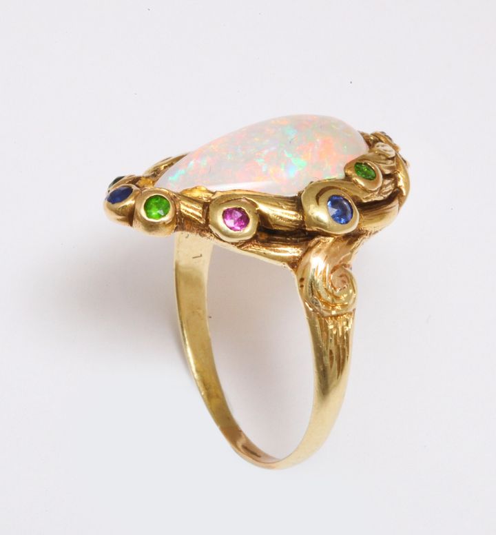 <p>Pat Saling’s Art Nouveau ring of center opal and acent colored stones in high karat gold, circa 1890.</p>