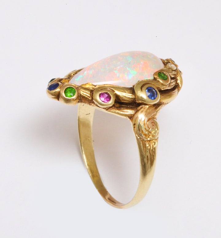 Pat Saling’s Art Nouveau ring of center opal and acent colored stones in high karat gold, circa 1890.